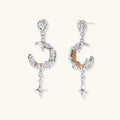 Detailed eco-brass dangle earrings featuring crescent moons with gold rope details and dangling star charms on white background.