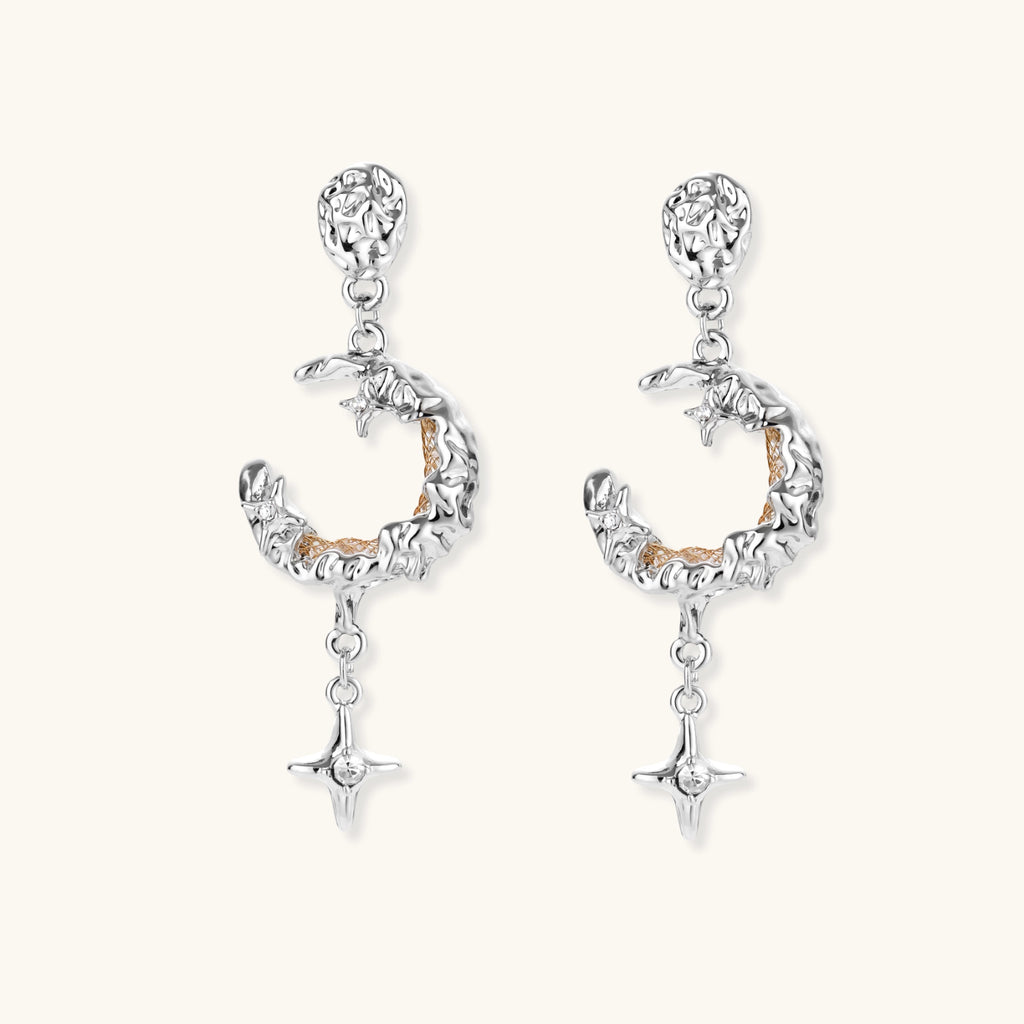 Detailed eco-brass dangle earrings featuring crescent moons with gold rope details and dangling star charms on white background.